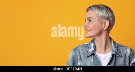Nice Promo. Smiling Mature Lady Looking With Interest At Copy Space Stock Photo