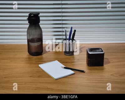 a drinking bottle and a set of stationery on the desk Stock Photo