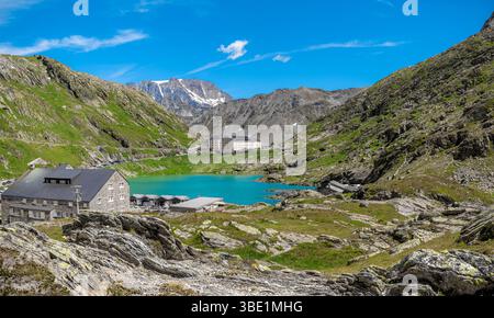 Panoramic photo of rugged mountains surrounding a small alpine lake at the Great St Bernard Pass in the Aosta Valley, Italy. Stock Photo