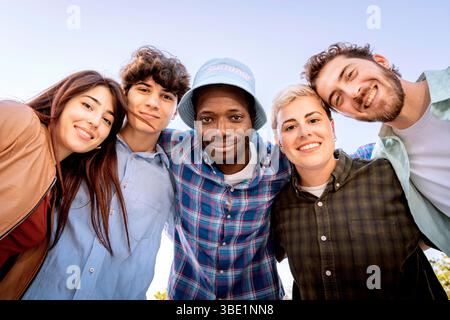 Group of cheerful young multiracial friends smiling together outdoors, unity and friendship concept Stock Photo