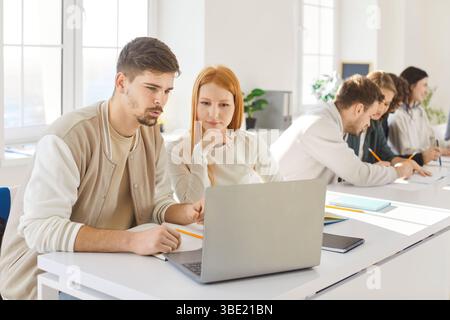 Team of young college friends students working online in pairs doing study project in university Stock Photo