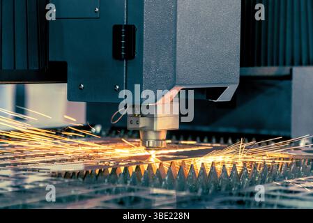 CNC laser cutting metal sheet with bright sparkle in factory. Stock Photo