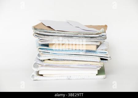 A stack of old notebooks, notepads and books on a white background, a symbol of study, education and work with documents Stock Photo