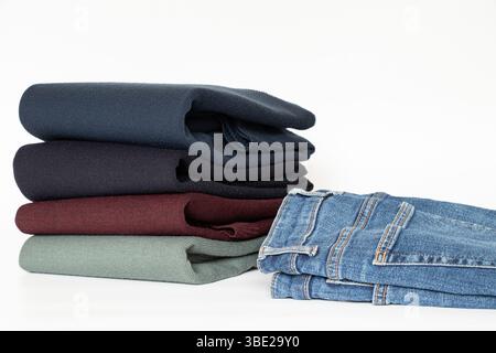 Folded men's sweaters and jeans on a white background, a set of clothes for a wardrobe, store or advertising Stock Photo