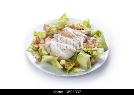 A fresh and crunchy Caesar salad made with crisp romaine lettuce, creamy Caesar dressing, crunchy croutons isolated on white background Stock Photo