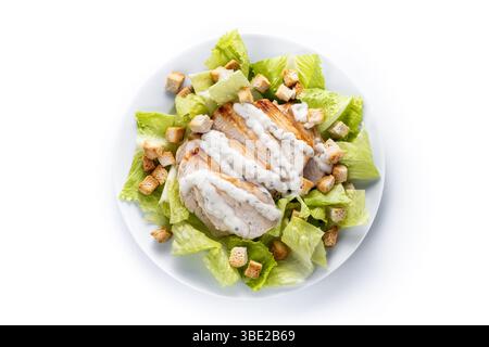 A fresh and crunchy Caesar salad made with crisp romaine lettuce, creamy Caesar dressing, crunchy croutons isolated on white background Stock Photo