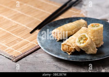 Crispy Spring Rolls on Ceramic Plate on wooden table Stock Photo