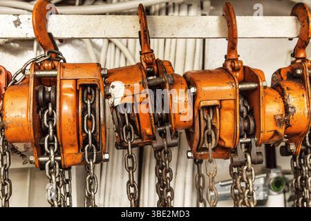 Chain hoists for lifting weights in a workshop close-up. Stock Photo