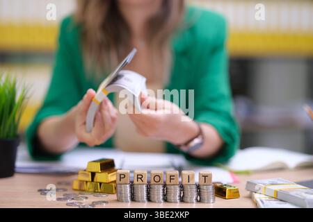 Calculating and Analyzing Profits Effectively Through Financial Records and Gold Bars Stock Photo