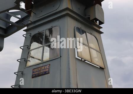 Close up showing external detail and patina of the operator’s cabin of a small Fiorentini dockside crane, preserved in the Italian port of Geova. Stock Photo