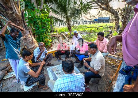 India, Kerala, Kochi, fishermen playing cards Stock Photo