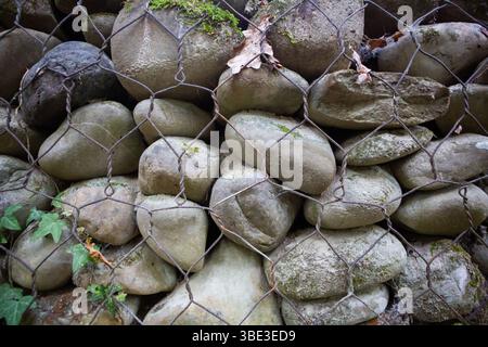 Gabion wall close up displaying textured river stones wire mesh. Stock Photo