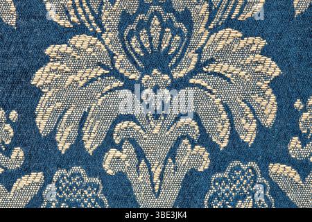 particular of a strip of elegant damask silk fabric with golden floral pattern on blue background Stock Photo