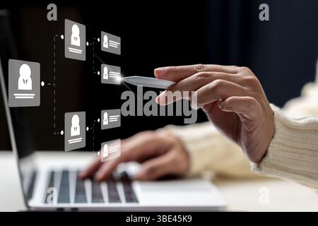 Businesswoman using laptop while touching the flowchart icon of a human representing potential candidates. Technology innovation on a virtual screen. Stock Photo