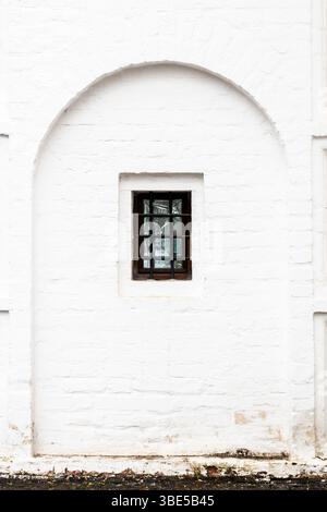 barred window in outdoor old white monastery wall in Andronikov Monastery of the Saviour in Moscow city Stock Photo