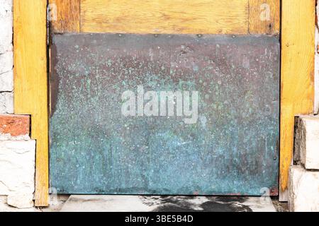 green and red brown surface of old copper plate closes hole in outdoor door close up Stock Photo