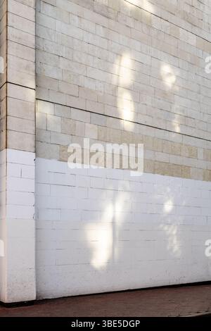 brick wall of city house painted white from below on spring day Stock Photo