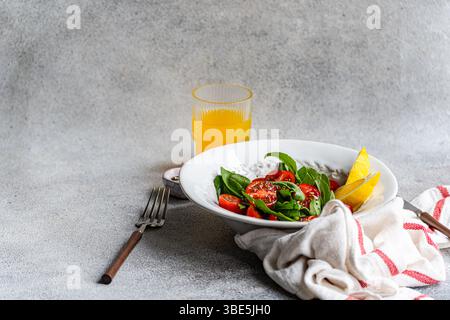 A refreshing arugula and herb salad, elegantly garnished with Himalayan salt, olive oil, cherry tomatoes, and seeds, creating a delightful mix of flav Stock Photo