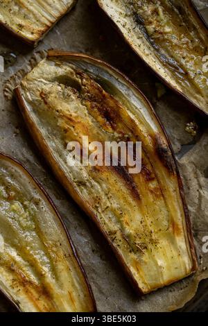 Close-up of oven-baked eggplant slices, showcasing their rustic texture and golden-brown finish. Perfect for Mediterranean dishes, they offer a health Stock Photo