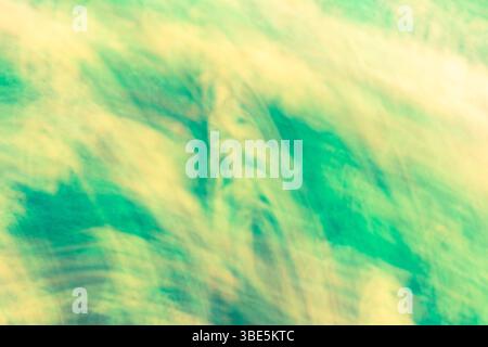 An abstract image with dynamic green and yellow hues blending together, creating a flowing, textured appearance. Ideal for backgrounds in artistic pro Stock Photo