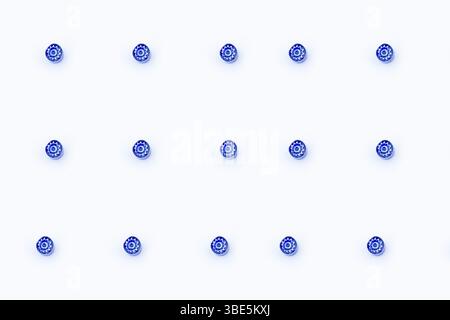 A minimalist image showing thirteen small blue Murano glass marbles arranged in a grid on a crisp white background. These delicate pieces are handcraf Stock Photo