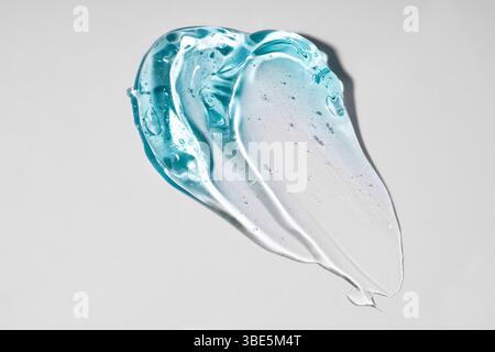 A close-up image of a translucent blue gel texture on a plain, light background. The smooth, flowing pattern highlights the unique, glossy appearance Stock Photo