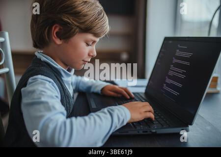 Cute boy learning to work on laptop at home Stock Photo