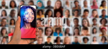 A hand holds a smartphone displaying a facial recognition feature Stock Photo