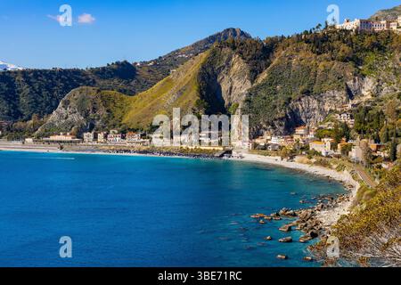 Taormina, Sicily, Italy - February 15, 2023: Panoramic view of Taormina shore at Ionian sea with Castello Saraceno castle, Giardini Naxos and Villagon Stock Photo