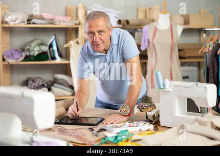 Man tailor makes pattern using tablet Stock Photo