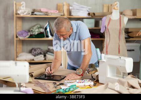 Man tailor makes pattern using tablet Stock Photo