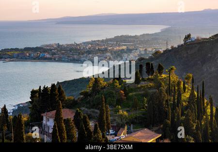 Taormina, Sicily, Italy - February 15, 2023: Panoramic view of Taormina shore at Ionian sea with Giardini Naxos and Villagonia towns and in Messina re Stock Photo