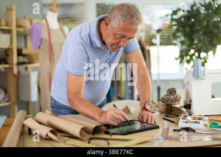 Man tailor makes pattern using tablet Stock Photo