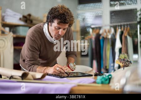 Man tailor makes pattern using tablet Stock Photo