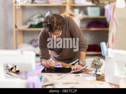 Man tailor makes pattern using tablet Stock Photo