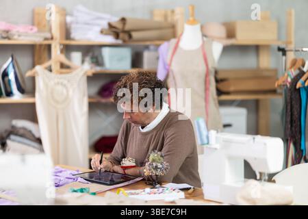 Man tailor makes pattern using tablet Stock Photo