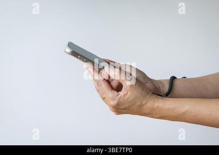Close up woman's hands using mobile smart phone, side view. Isolated on white background. Stock Photo