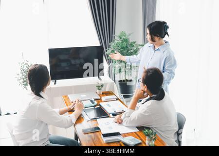 People meeting using laptop computer, calculator, stock market chart paper for analysis plans to improve quality. Team working on project. Analysis bu Stock Photo