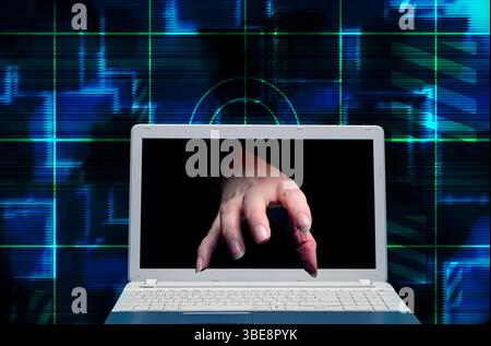 hand coming out of a computer screen, cyberattack and cybercrime concept Stock Photo