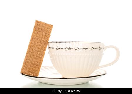 Sweet waffles on a ceramic saucer with a cup, close-up, isolated on a white background. Stock Photo