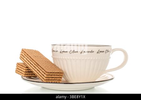 Sweet waffles on a ceramic saucer with a cup, close-up, isolated on a white background. Stock Photo