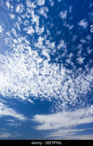 Beautiful small white clouds covering a deep blue sky on a sunny day Stock Photo