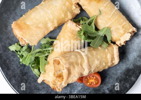Crispy vegetables spring Rolls on Ceramic Plate isolated on white background Stock Photo