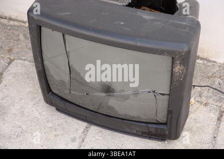 Old broken CRT TV set on a city street Stock Photo