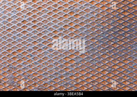 Industrial metal texture pattern. Grid mesh close-up view. Repeating geometric structure. Rusty surface background. Abstract metallic design. Stock Photo