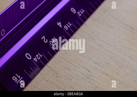 Ruler triangular in inches centimeters on white table. Hobby diy Stock Photo