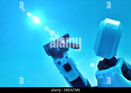 humanoid robot stands showing hand and futuristic with people blurred in background Stock Photo