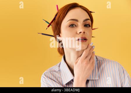 A young woman with red hair poses with vibrant pencils, showcasing her artistic spirit. Stock Photo