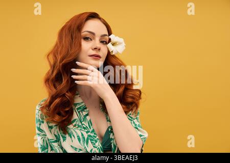 A stunning young woman poses gracefully, highlighting her lush curls and a delicate white flower. Stock Photo