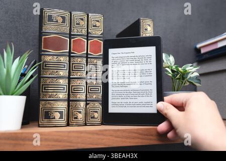 E-book reader device on shelf in home library Stock Photo